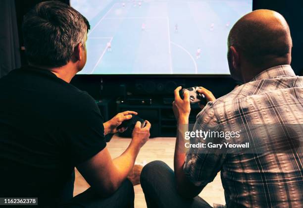 two men playing video games at home - man cave 個照片及圖片檔