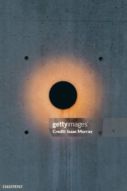 lighting fixture illuminating concrete wall - fitting stockfoto's en -beelden