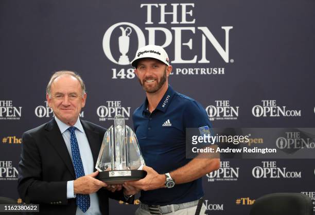 Official World Golf Ranking Chairman Peter Dawson presents Dustin Johnson of the United States with the OWGR McCormack Award during a practice round...