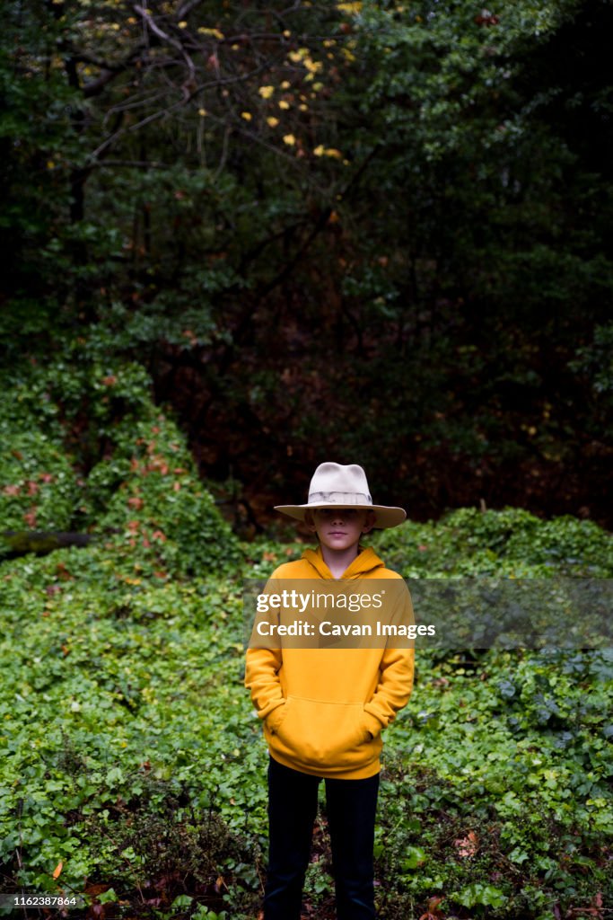 Portrait of boy wearing large fedora in nature