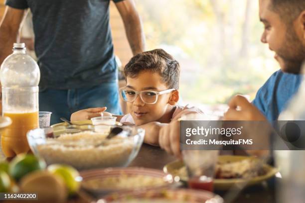 embarrassed boy during lunch with family - awkward dinner imagens e fotografias de stock