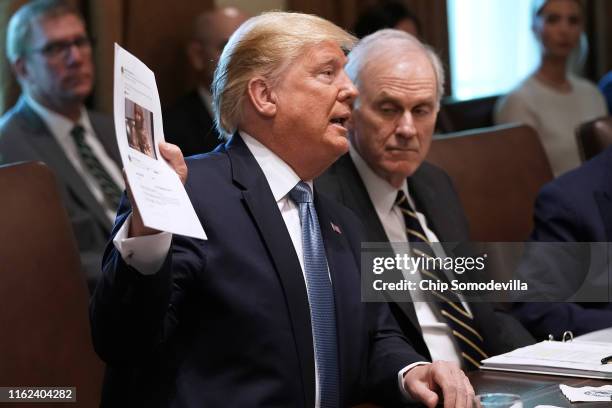 President Donald Trump holds up a photograph of Rep. Ilhan Omar during a cabinet meeting at the White House July 16, 2019 in Washington, DC. Trump...