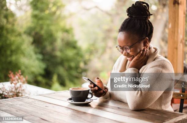 catching up with friends online - woman cafe smartphone stock pictures, royalty-free photos & images