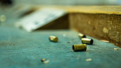 Empty pistol bullet shells on wooden table in a shooting range