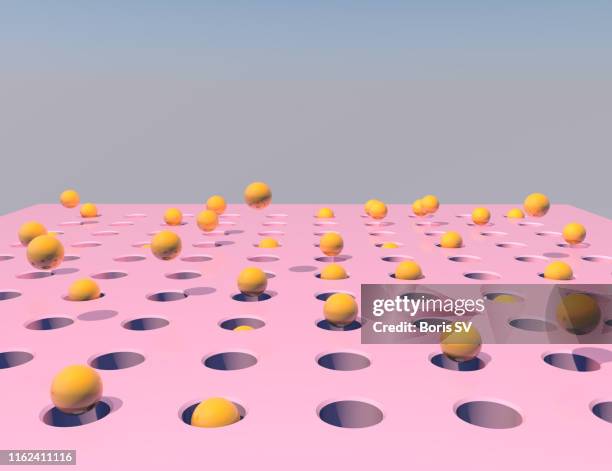spheres hitting holes - pitfall stockfoto's en -beelden