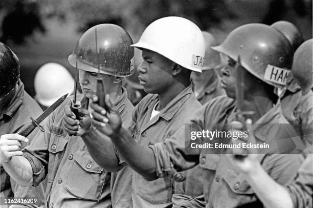 Three recently drafted soldiers examine their knives during basic training at Fort Jackson, Columbia, South Carolina, October 1972. They were among...