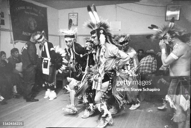 Oglala Lakota dancer, dressed in traditional regalia, perform indoors at the Pine Ridge Indian Reservation, South Dakota, 1963.