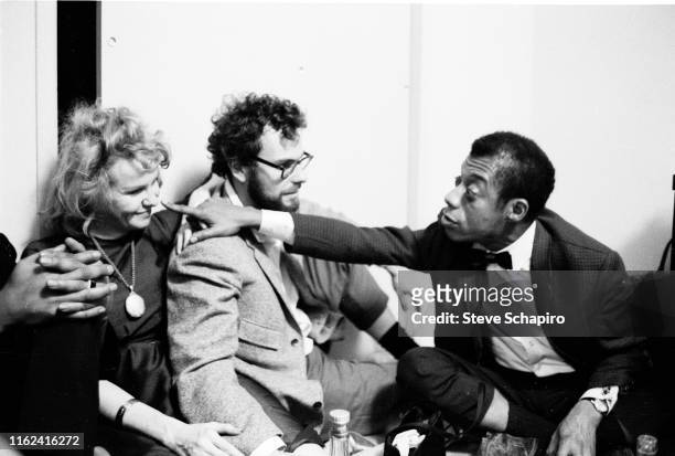 View of, from left, married American actors Geraldine Page and Rip Torn , and author & activist James Baldwin as they sit together on the floor...