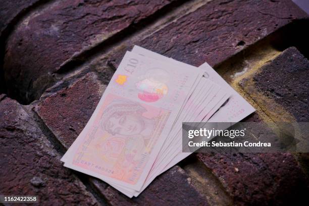 british currency on the brick wall, travel in london, england, uk. - ten pound note stock pictures, royalty-free photos & images