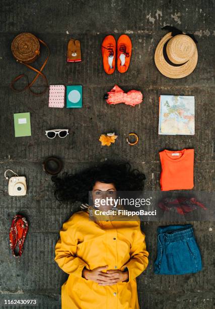 young adult woman lying down with clothes and various objects - yellow belt stock pictures, royalty-free photos & images