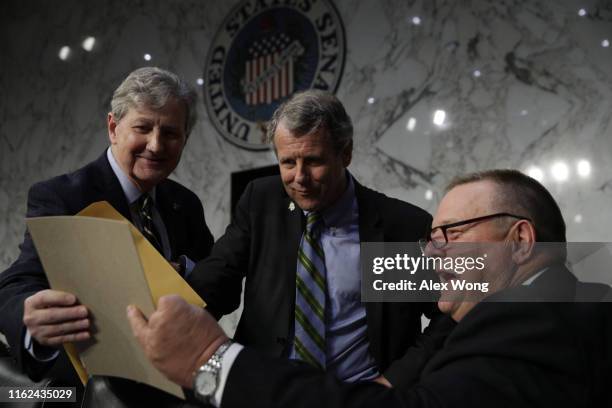 Sen. John Kennedy shows a picture to Sen. Sherrod Brown and Sen. Jon Tester prior to a hearing before Senate Banking, Housing and Urban Affairs...