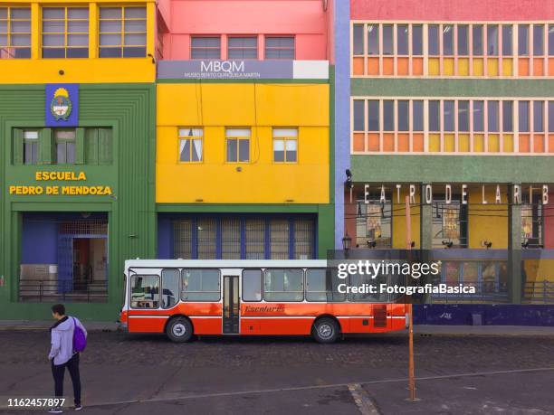 カラフルな建物の前でスクールバス - bus front ストックフォトと画像