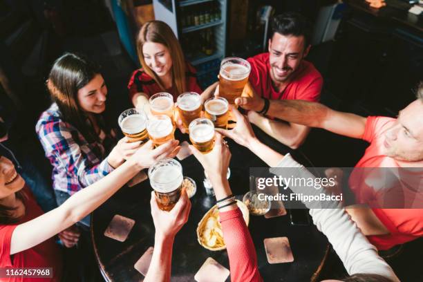 gruppe glücklicher freunde, die in der brauerei bier trinken - irish pub stock-fotos und bilder