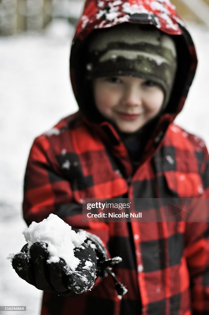 Boy standing with snowball