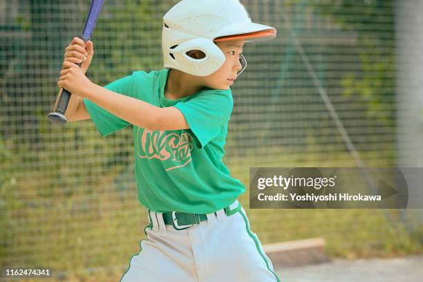 kids (8-9) swinging baseball bat on field - child batting stock pictures, royalty-free photos & images