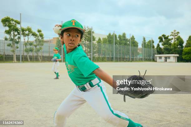 japanese kid (6-7) baseball player throwing ball on field - baseball sport 個照片及圖片檔