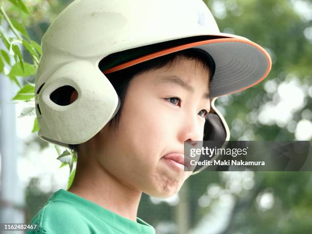 the boy is disappointed and crying during the baseball game. - effort face stock pictures, royalty-free photos & images