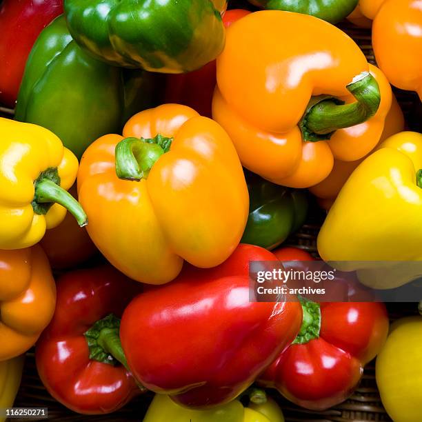 red green yellow and orange peppers as a background - yellow bell pepper stock pictures, royalty-free photos & images