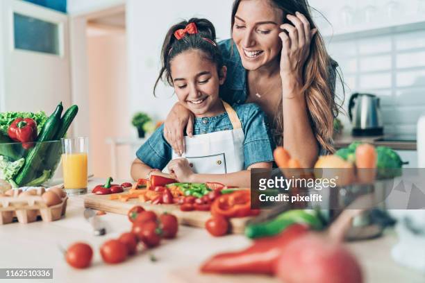 madre che insegna a sua figlia a cucinare - woman cook foto e immagini stock