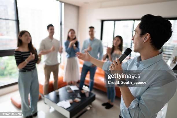 gruppo di amici che organizzano una festa karaoke - cantare una serenata foto e immagini stock