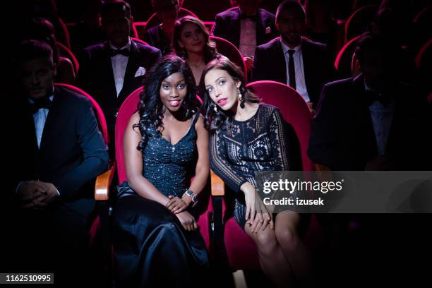 woman talking with friend while watching opera - opera audience stock pictures, royalty-free photos & images