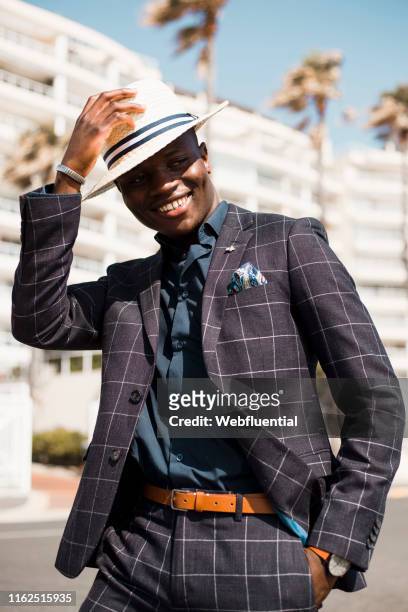 Young black South African man wearing a suit and hat outdoors
