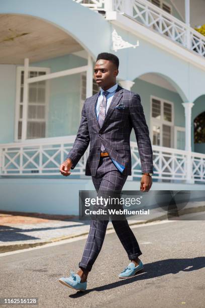 Young black man wearing a suit suit walking outdoors