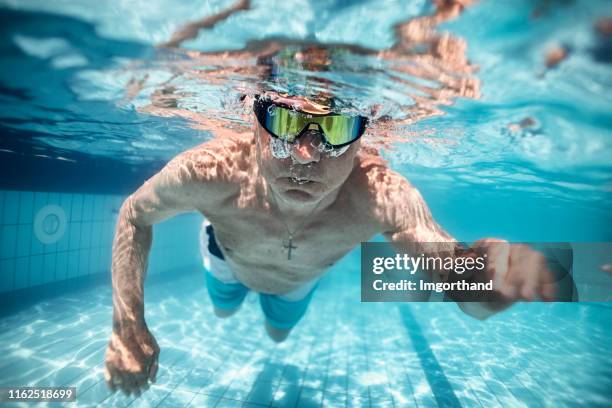 senior man swimming in pool - man underwater stock pictures, royalty-free photos & images