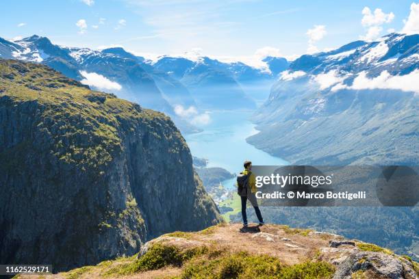 tourist admiring the view from the top of a mountain in loen, norway - norwegian culture ストックフォトと画像