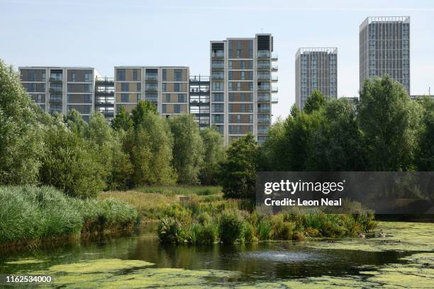 Residential apartment blocks are seen in the distance, beyond the ponds and woodlands in the Queen Elizabeth Olympic Park on July 17, 2019 in London,...