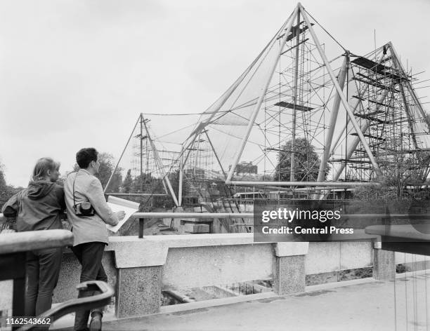Two visitors look at the tetrahedrons of the London zoo's new aluminium aviary designed by Antony Armstrong-Jones, 1st Earl of Snowdon and built on...
