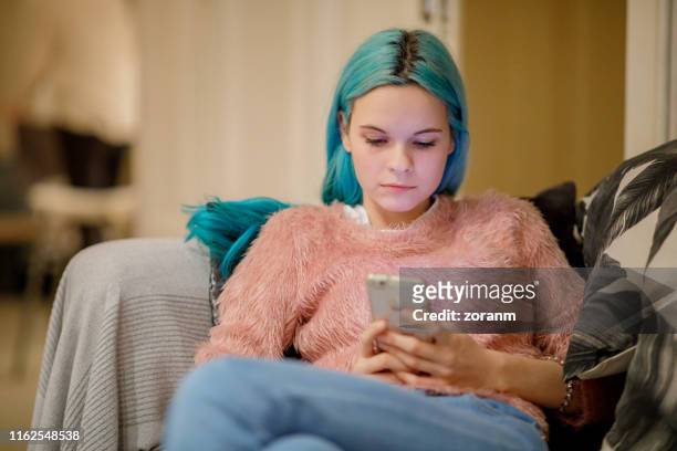 young woman millennial working at home on her mobile phone - legs crossed at knee stock pictures, royalty-free photos & images