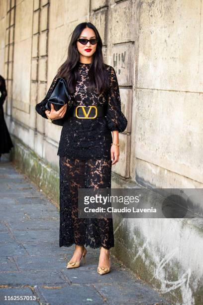 Nicole Warne, wearing a long black lace dress, Valentino belt, nude Valentino heels and black Valentino bag, is seen outside VALENTINO show during...