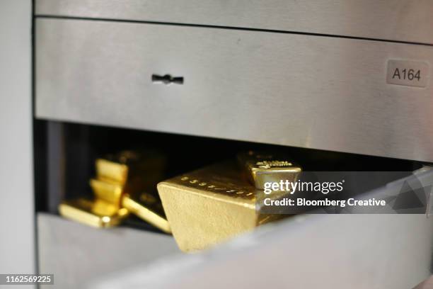 gold bullion bars sit in a safety deposit box - goldbarren stock-fotos und bilder