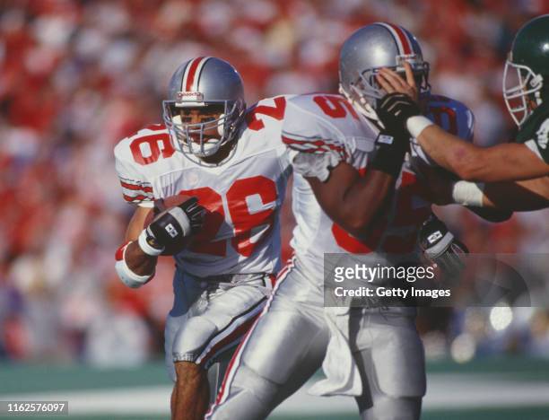 Robert Smith, Running Back for the Ohio State Buckeyes runs the ball against the Michigan State Spartans defense during their NCAA Big Ten conference...