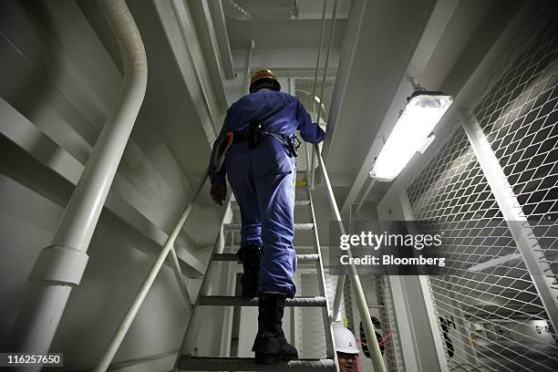 Worker climbs a ladder in the Nippon Yusen K.K.'s car transporter ship, Auriga Leader, at Mitsubishi Heavy Industries Ltd.'s Honmoku plant in...