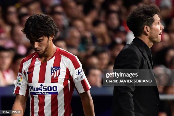 Atletico Madrid's Portuguese midfielder Joao Felix walks past Atletico Madrid's Argentinian coach Diego Simeone as he leaves the pitch after getting...