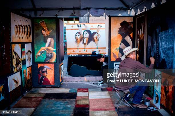 Rueben Richards of Dennehotso, Arizona, works on his art while waiting for patrons to come during the 98th annual Santa Fe Indian Market, the largest...