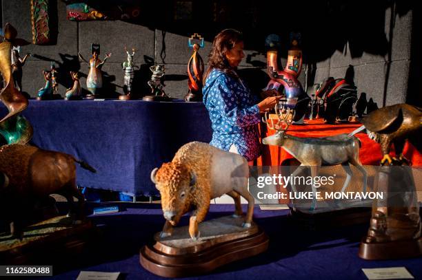 Althea Cajero, of the Santo Domingo Pueblo New Mexico prepares her stall for patrons during the 98th annual Santa Fe Indian Market, the largest...