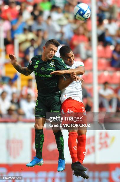 Ricardo Chavez of Necaxa jumps for the ball with Brian Lozano of Santos during the Mexican Apertura 2019 tournament football match at Victoria...