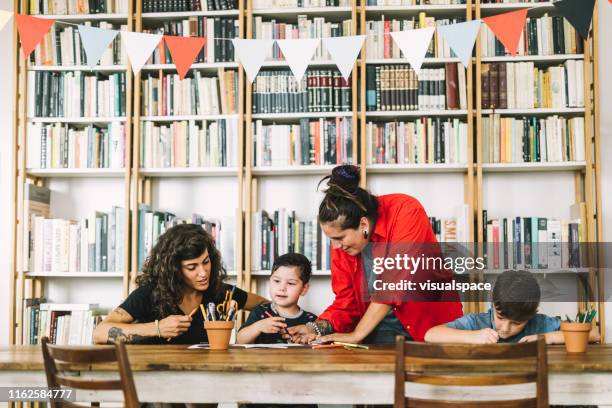 homosexual parents assisting children in drawing - family with two children stock pictures, royalty-free photos & images