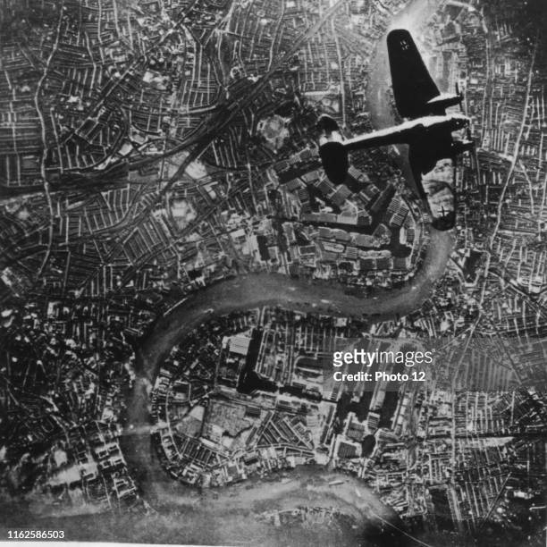 German Heinkel He-111 bomber of the Luftwaffe flying over the India Docks of London, during the Blitz, September 7, 1940.