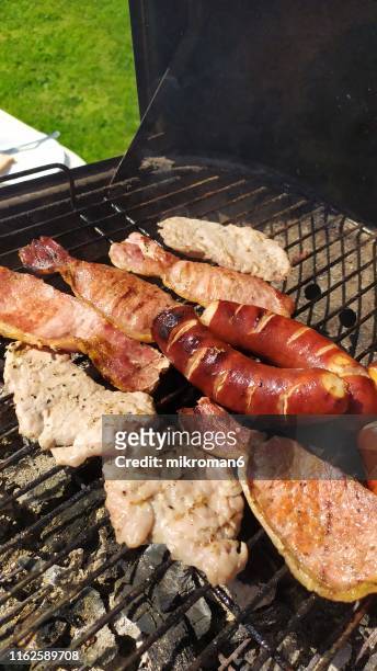 bbq with bacon sausages on top. - eating spicy food stock pictures, royalty-free photos & images