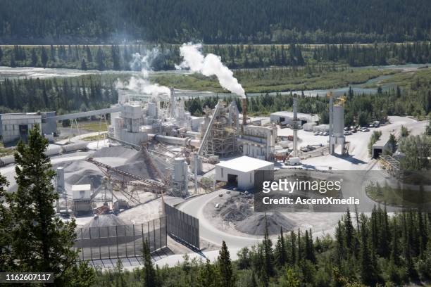 overview of cement plant in valley and forest - industrial pollution stock pictures, royalty-free photos & images