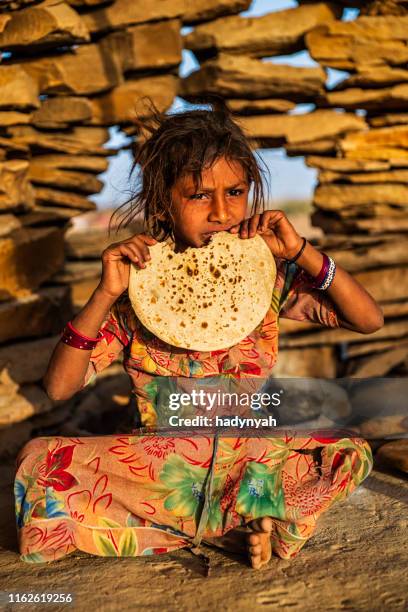 indian little girl eating chapatti, flat bread, desert village - roti stock pictures, royalty-free photos & images