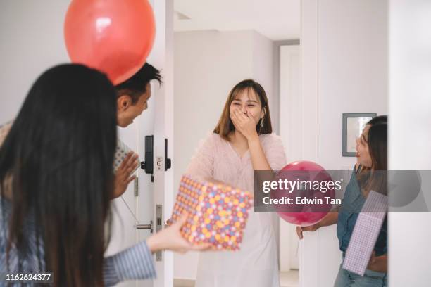 een groep van aziatische chinese vrienden en collega verrassen hun vriend met verjaardagsfeestje viering verwelkomt haar aan de deur - chinese birthday stockfoto's en -beelden