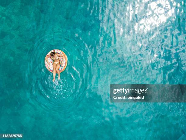 woman enjoying summer - floating on water stock pictures, royalty-free photos & images
