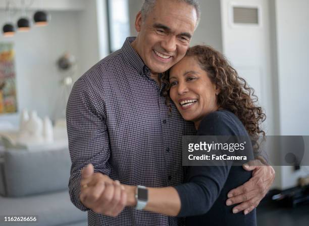 a middle age couple laughing and dancing together - baby boomer stock pictures, royalty-free photos & images