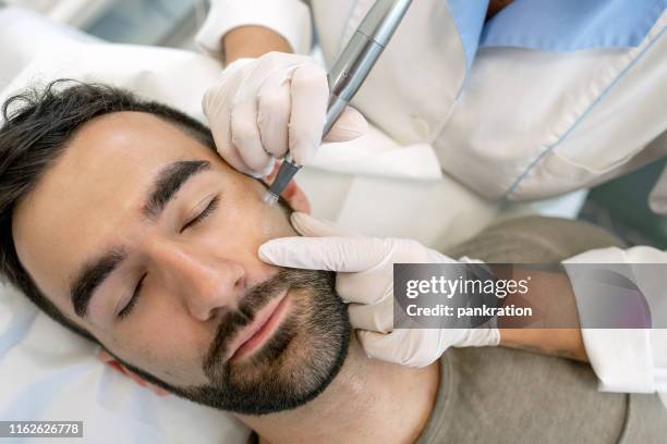 young man in beauty clincic having dermatude meta therapy, rejuvenating treatment,  by cosmetologist - beauty treatment stock pictures, royalty-free photos & images