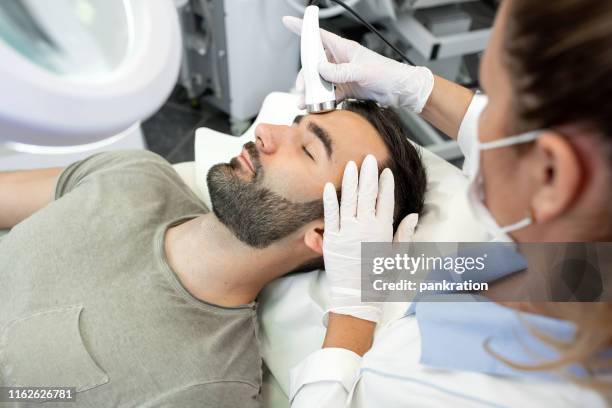 professional beautican provides ultrasound facial treatment - men facial stock pictures, royalty-free photos & images